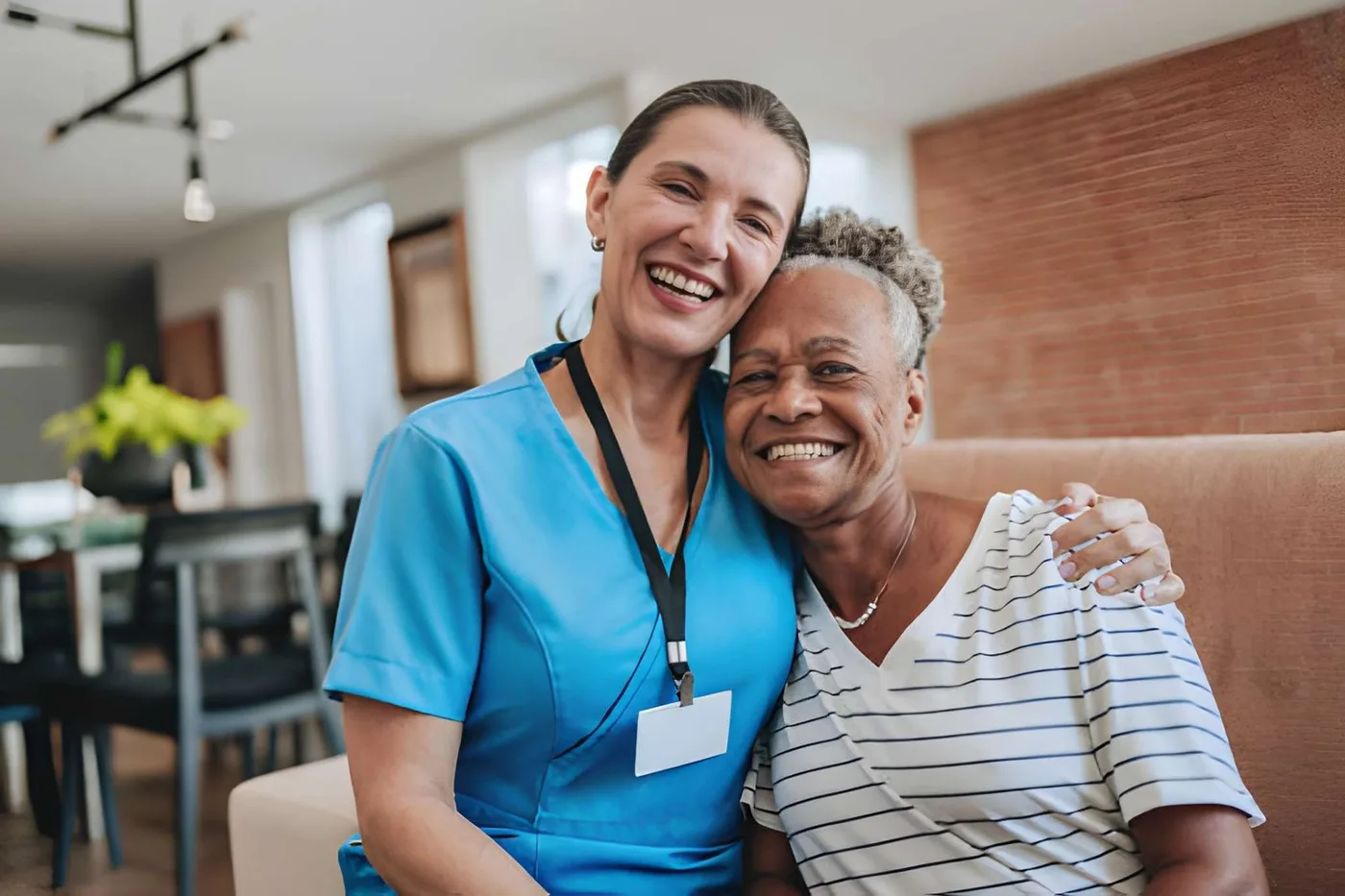 A caregiver and an older woman sharing a warm moment at home